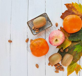 白壳坚果白木板上的水果平铺拍摄背景