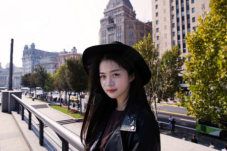 文艺女性拿帽子文艺美女与上海建筑合影背景