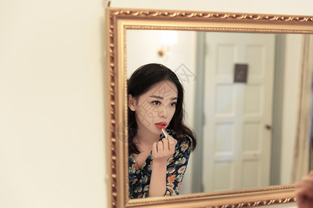 漂亮的镜子知性美女镜子前涂口红背景