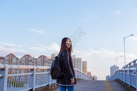 室外广告背包旅行墨镜女人帅气回头背景