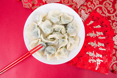 饱满的饺子新春过年冬至红色背景上的一盘饺子背景