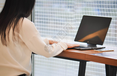 电脑侧面女白领在咖啡店商务办公背景