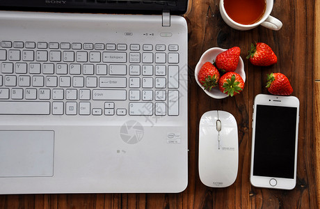 手机和杯子特写木板桌上的数码产品背景