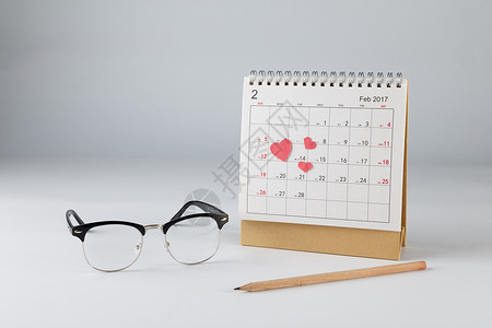 情人节日历爱心眼镜铅笔在白色背景上背景图片