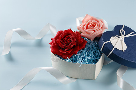 金边红色绸带情人节爱心礼盒缎带红色粉色玫瑰花在浅蓝色上背景
