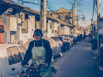 怀旧自行车穿梭在北京胡同的老手艺人背景