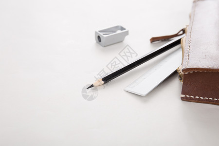 笔袋散落的铅笔尺子和卷笔刀背景图片