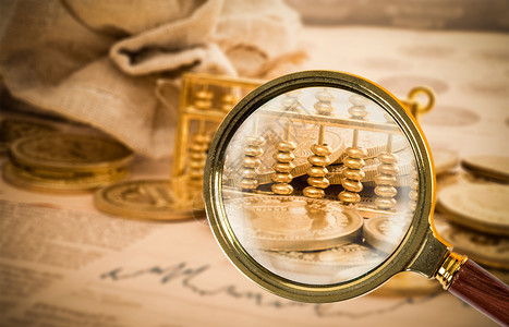 存储金币放大镜照亮金币算盘设计图片