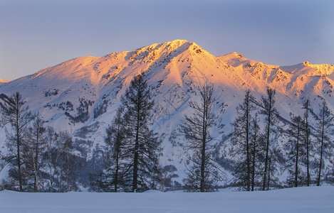 日出阳光洒在雪山上背景图片