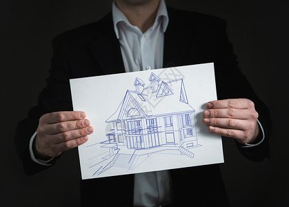 白纸黑画素材商务男士拿着房屋线稿设计图片