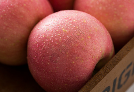 保鲜水果带着露水的红苹果放在木盘子里背景