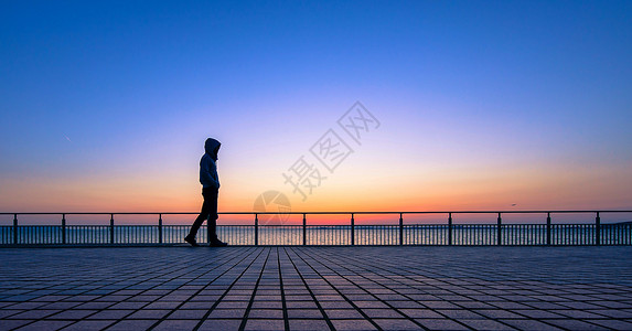 河道护栏夕阳下行走的人背景