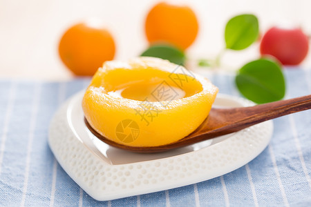 一只黄桃一片蜜桃罐头放在小盘子里背景