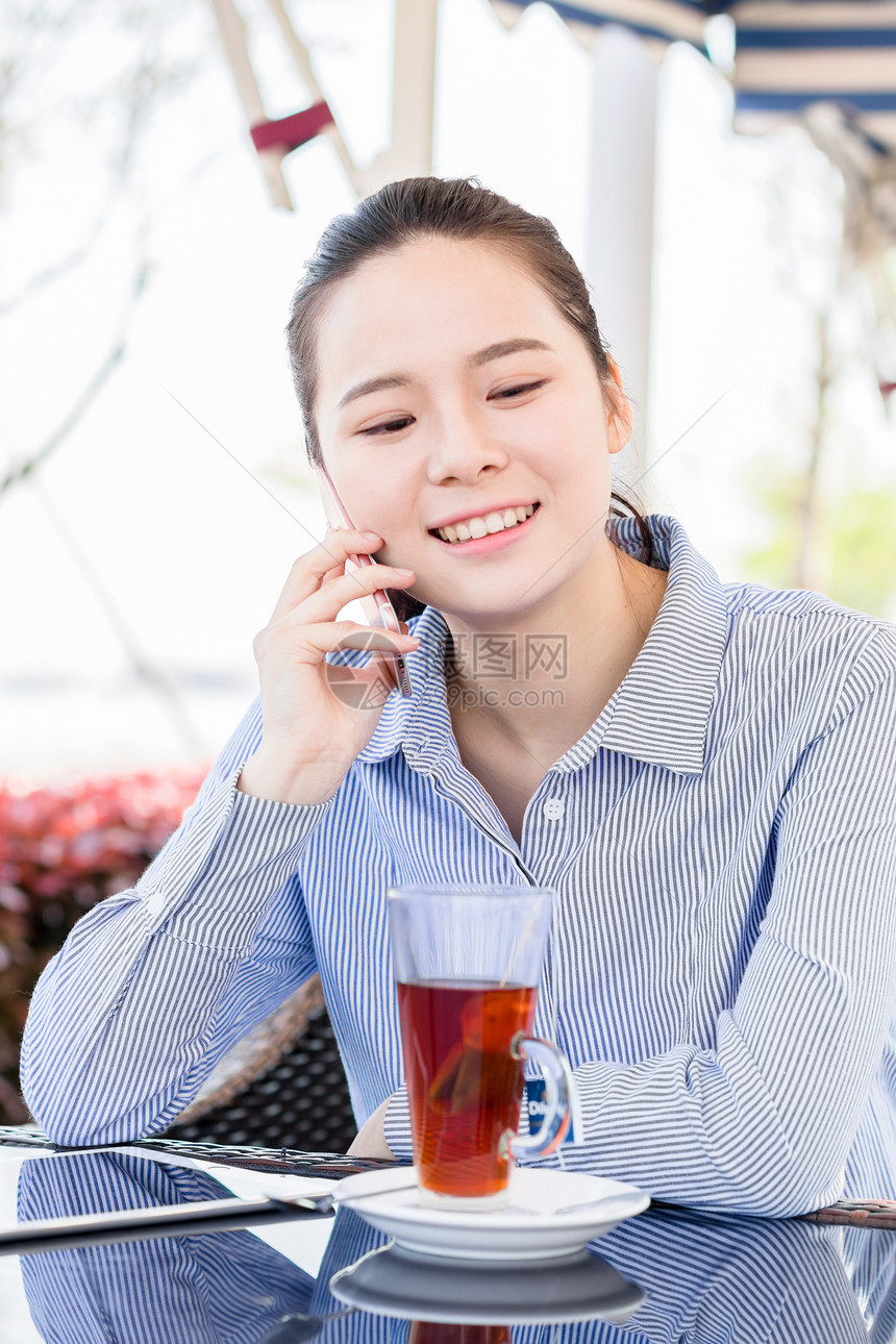 年轻女子在咖啡馆打电话图片