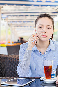 坐着喝茶女孩年轻女性在咖啡店打电话背景