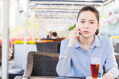 坐着喝茶女孩年轻女性在咖啡店打电话背景