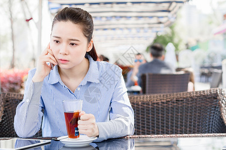 坐着喝茶女孩年轻女性在咖啡店打电话背景