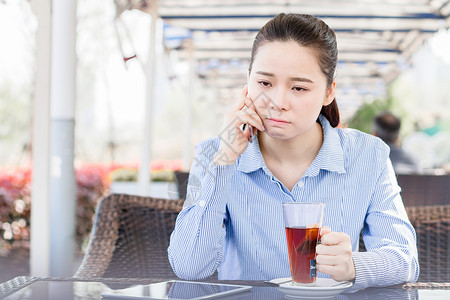 坐着喝茶的嫦娥年轻女性在咖啡店打电话背景