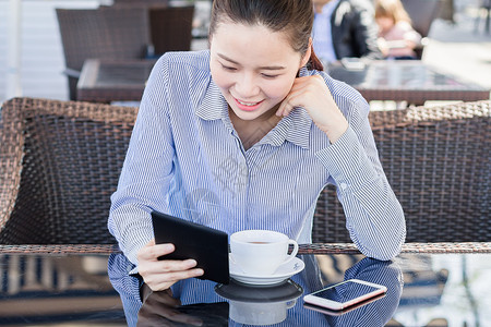 坐着打电话年轻女性咖啡店阅读电子书背景