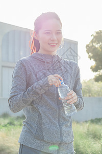 年轻女性户外运动休息喝水图片