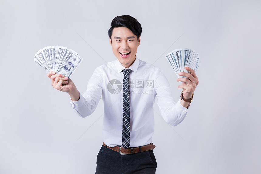 手拿美钞微笑的商务男性图片
