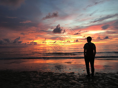 海浪剪影夕阳下的人物剪影背景