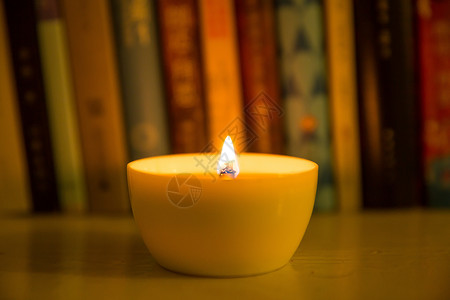 彩色的火一杯燃烧的蜡烛放在书桌旁背景