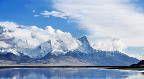 平静浩渺湖面西藏的雪山和天空背景