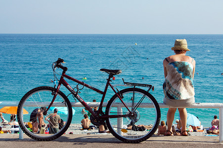 尼斯卡洛斯海边的游客和自行车背景