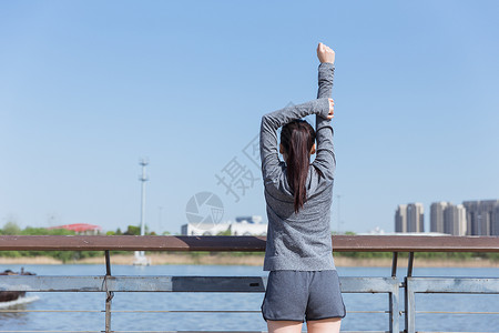 运动女孩阳光下拉伸身体背景图片