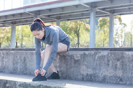 运动女孩户外休息系鞋带图片