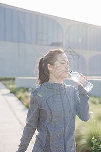 喝矿泉水落日运动女孩休息喝水背景