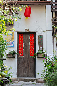 大风吹挂在古朴大门上的灯笼随风摇曳背景