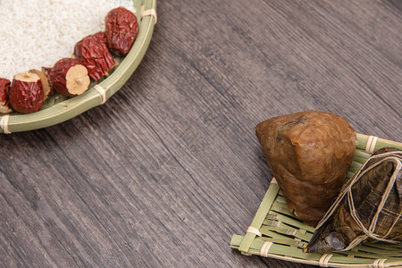 端午节木板上的粽子与米红枣背景图片