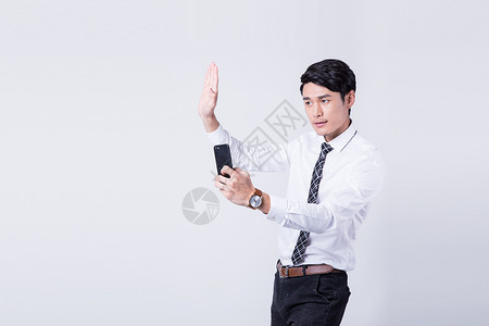 商务男性拿着手机指导手势图片