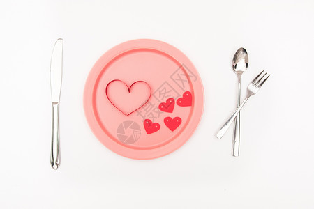 深粉色的彩带刀叉餐盘创意摄影背景
