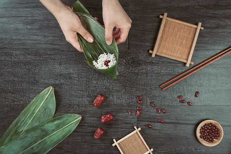 包粽子女人端午节粽子食材背景