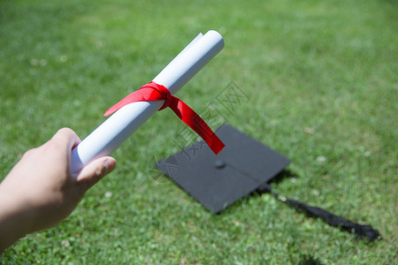 毕业季草地上手拿证书的人图片