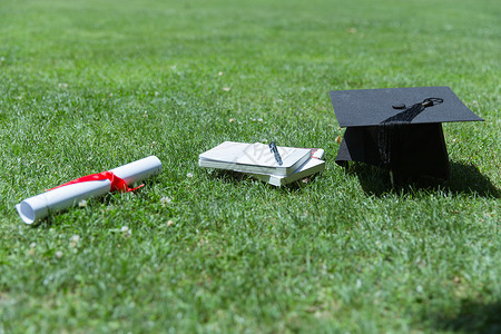 大学草地上的书本证书学士帽图片