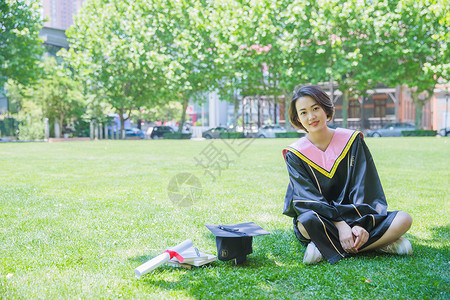 坐在草地上清新学士服女学生高清图片