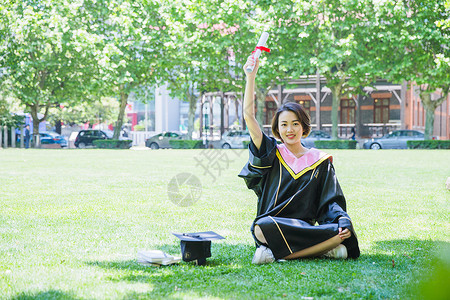 长知识坐在草地上清新学士服女学生背景