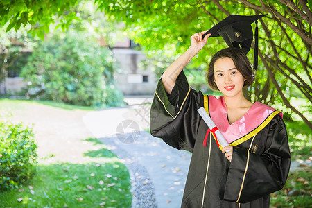 毕业校园树林穿学士服的女学生高清图片