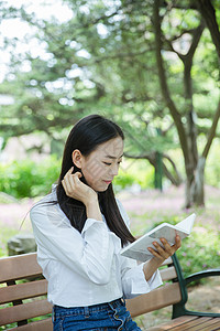 清新女大学生坐在椅子上看书图片