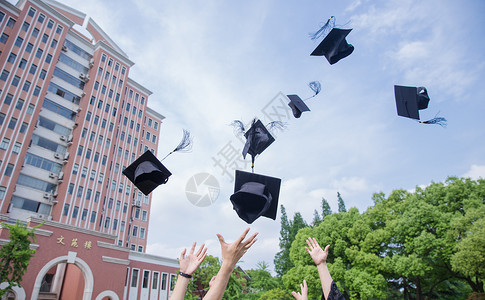 庆祝毕业毕业季青春大学生们扔学士帽背景