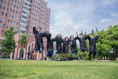 跳跃学士服男孩毕业季青春大学生们牵手在跳跃背景
