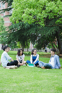 男女大学生们坐草地上聊天休息图片