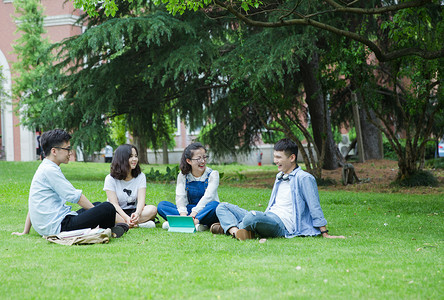 坐男男女大学生们坐草地上聊天休息背景