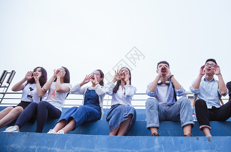 举手的男孩文艺青春大学生们举手呐喊背景