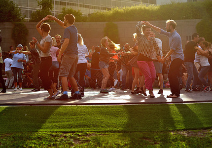 夕阳下的舞蹈仲夏的芬兰 人们在夕阳照射的草地上跳舞欢快背景