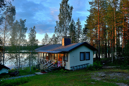 夕阳下的湖畔白桦林度假小木屋背景图片